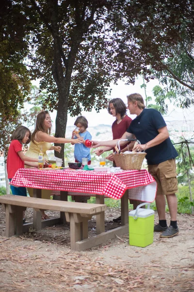 Happy familie setting tafel voor picknick — Stockfoto