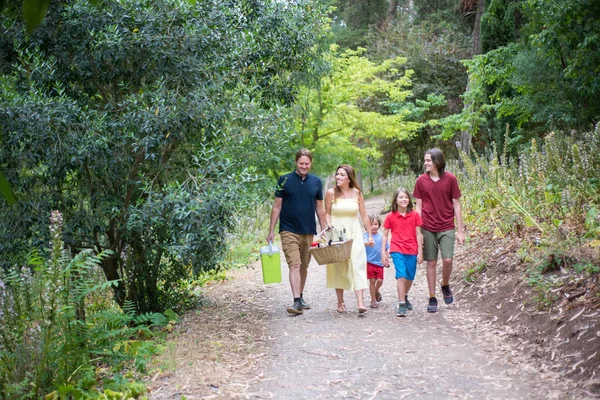 Счастливая улыбающаяся семья гуляет в парке — стоковое фото