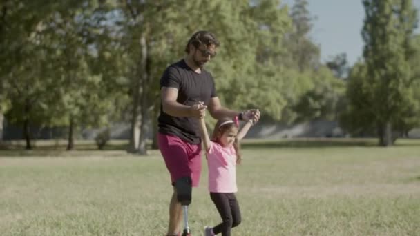 Plan de suivi de papa handicapé soulevant sa fille par les mains — Video