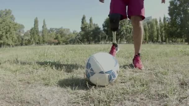 Movimiento vertical del hombre discapacitado poniendo su pierna en la pelota — Vídeos de Stock