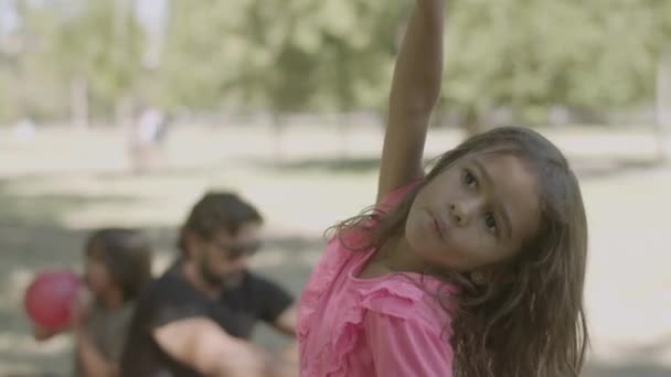 Вид спереди, как маленькая девочка грабит и позирует перед камерой — стоковое видео