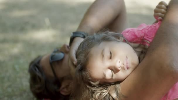 Närbild av sovande flicka ligger med pappa på gräsmattan — Stockvideo