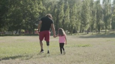 Parkta yürüyen engelli baba ve kızın arka plan görüntüsü