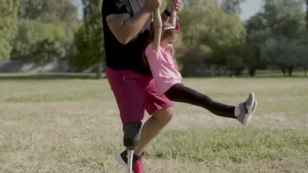 Papá con pierna artificial caminando y sosteniendo las manos de los niños — Vídeos de Stock