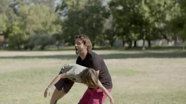 Père handicapé soulevant et encerclant fils sur les mains dans le parc — Video