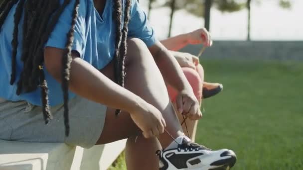 Side visning af kvinder sidder på bænken og snøring sneakers – Stock-video