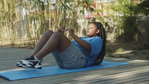 Statische Aufnahme einer dicken Frau, die im Sommerpark Bauchmuskeln trainiert — Stockvideo