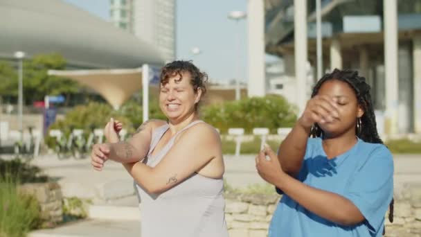 Långsamma rörelser av olika kvinnor värmer upp innan utomhus träning — Stockvideo