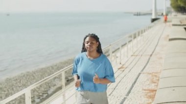 Parkta kendi içinde koşan bir kadının el kamerasıyla çekilmiş fotoğrafı.