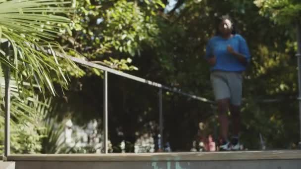 Вид спереду на тіло позитивна жінка біжить сходами в парку — стокове відео