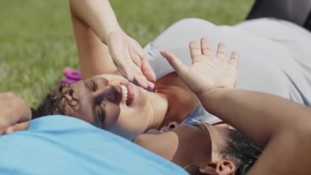 Nahaufnahme von müden Frauen, die nach intensivem Training auf dem Rasen liegen — Stockvideo