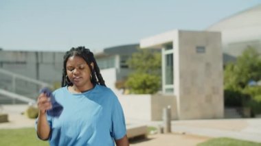 Parktaki eğitimden sonra terini havluyla silen yorgun bir kadın.