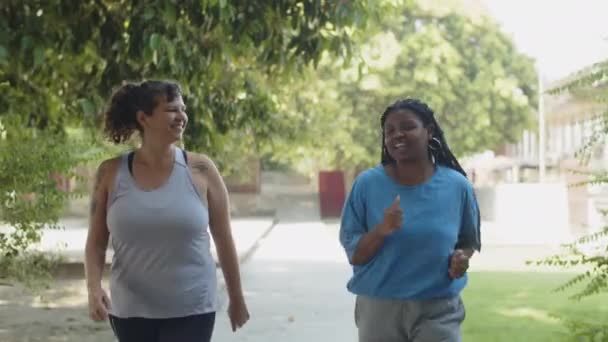 Vista frontale del corpo donne positive che fanno jogging nel parco — Video Stock