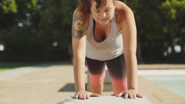 Widok z przodu ciało pozytywne kobieta robi pompki z ławki — Wideo stockowe
