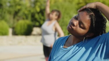 Kadının orta boy boyun kaslarını kapalı gözlerle esnetirken görüntüsü.