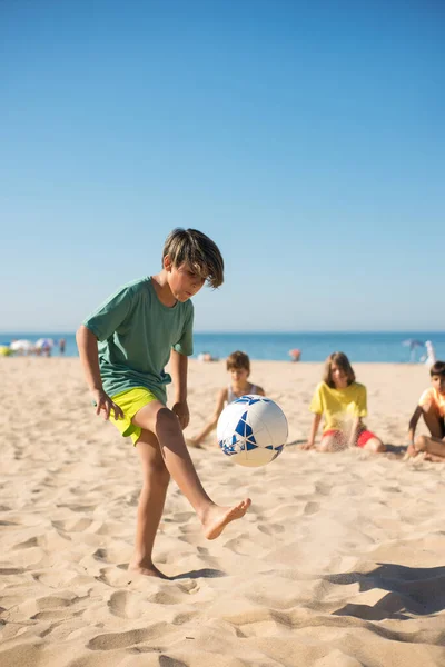 Concentrato preteen ragazzo giocare con palla su sabbia — Foto Stock