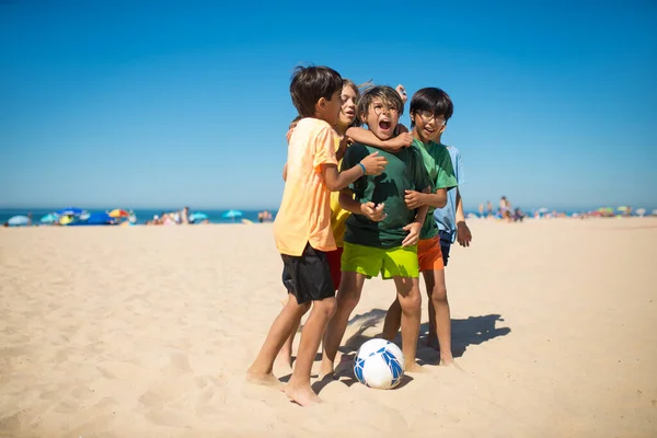 Gioioso preteen ragazzi abbracciare dopo gioco sulla spiaggia — Foto Stock