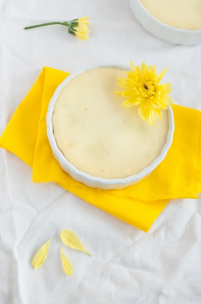 Cheesecake e fiori su tovagliolo giallo e tovaglia bianca — Foto Stock
