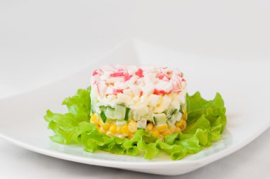 Katmanlı Yengeç Salata marul yaprakları üzerinde sopa. 