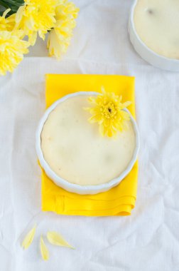 Peynir pasta ve bir buket sarı çiçek, üstten görünüm