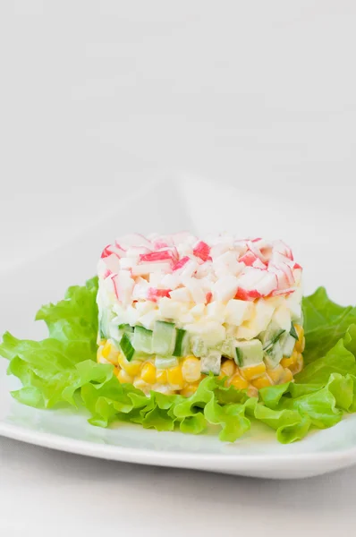 Salade de bâtonnets de crabe sur nappe blanche — Photo