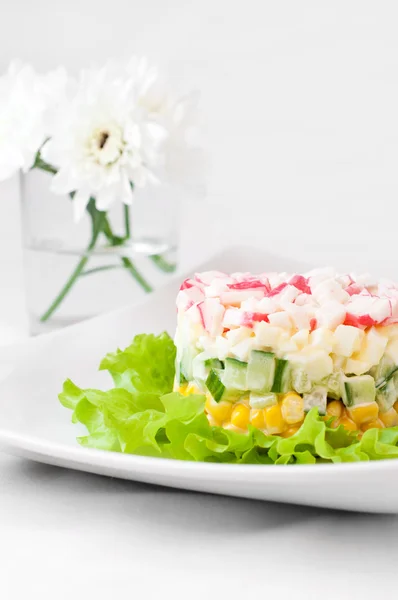 Salade de bâtonnets de crabe sur nappe blanche — Photo