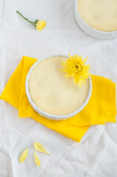 Cheesecake e fiori su tovagliolo giallo e tovaglia bianca — Foto Stock