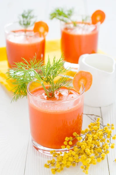 Carrot juice, milk jug and mimosa branch