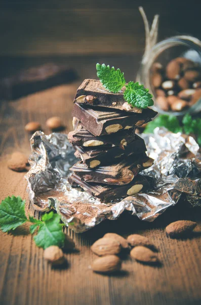 Chocolate escuro com nozes, folhas de hortelã, amêndoas — Fotografia de Stock