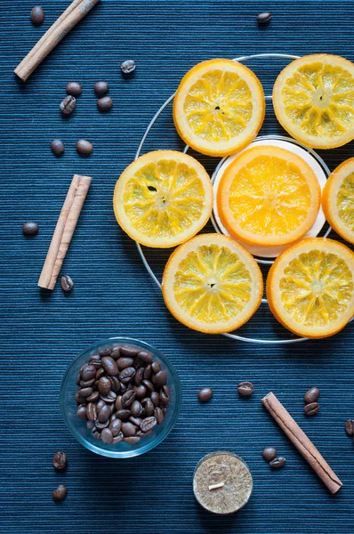 Laranjas caramelizadas, canela, velas e grãos de café — Fotografia de Stock