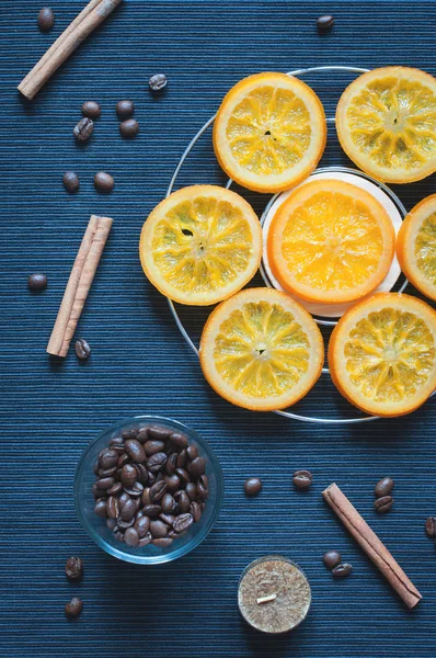 Laranjas caramelizadas, canela, velas e grãos de café — Fotografia de Stock