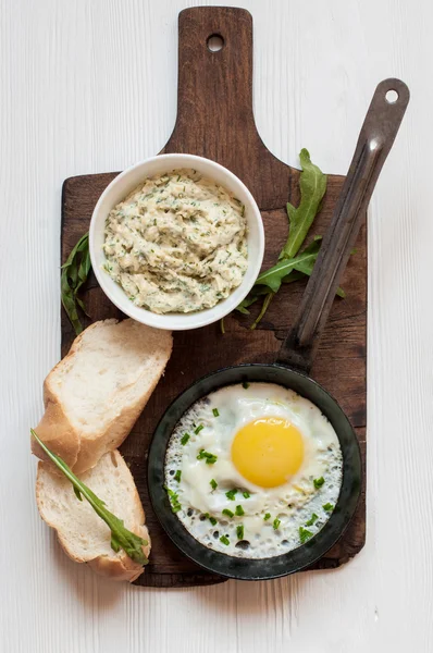 Sahanda yumurta, peynir sos, ekmek ve roka — Stok fotoğraf