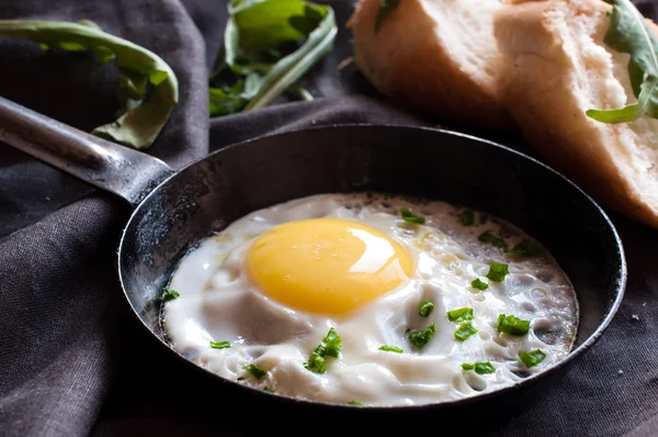 Gebakken ei in de pan en gesneden brood — Stockfoto