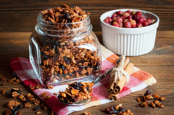 Granola em frasco de vidro aberto e morangos selvagens — Fotografia de Stock