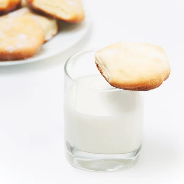 Сладкое печенье со стаканом молока на белом — стоковое фото
