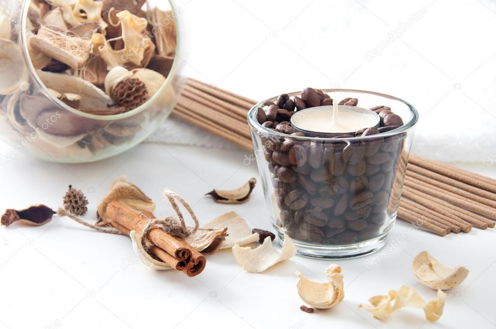 Aroma candle in the glass with coffee beans, cinnamon and perfum