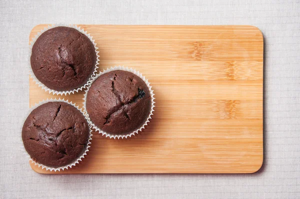 Chocolate muffins on the wood cutting board, text space — Stockfoto