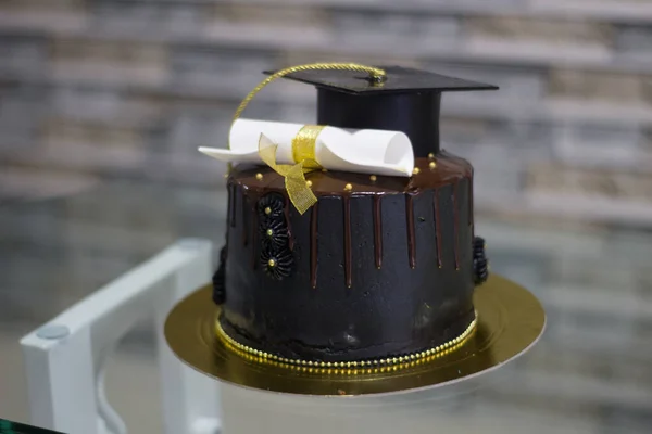 degree cake with a black hat and white diploma