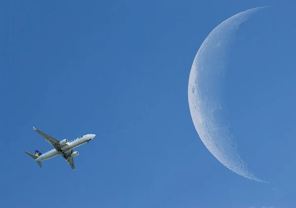 在蓝天中间的小飞机 背景是月亮 — 图库照片