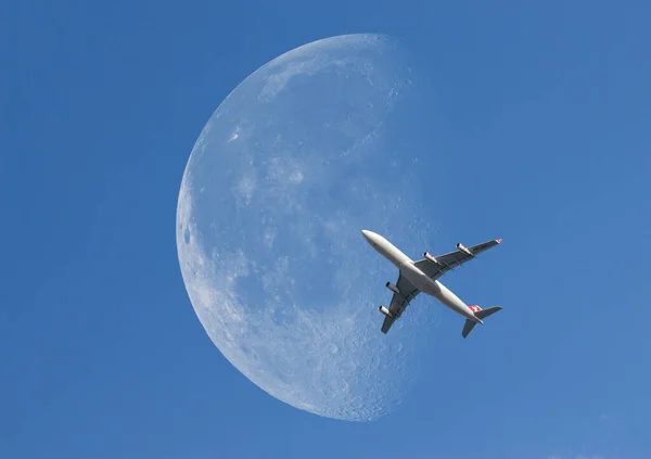 在天空中穿过白色月亮的飞机 — 图库照片