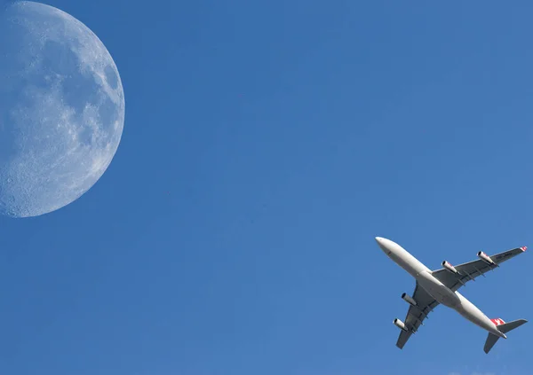 带着一颗大月亮在天空中起飞的飞机 — 图库照片
