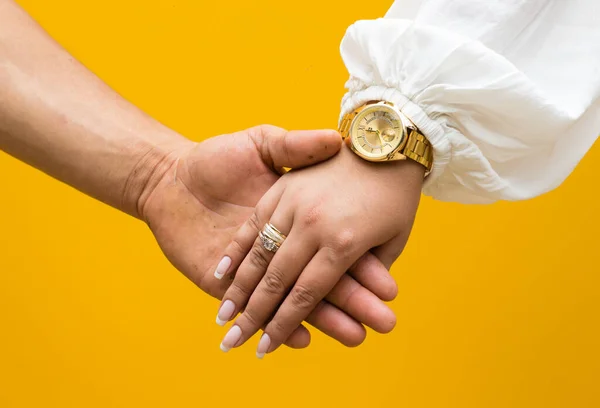 Ręce Trzymające Się Ręce Zegarem Żółtym Tle — Zdjęcie stockowe