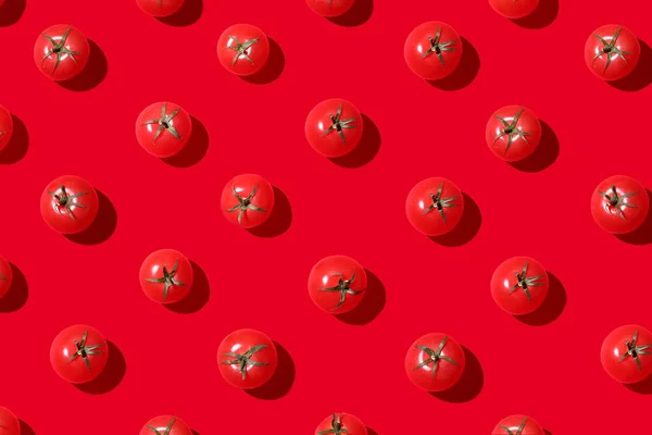 붉은 바탕에 단단 한 것으로 된 체리 토마토 무늬가 있습니다. 평평하게 누워 있는 위에서 바라본 모습 — 스톡 사진