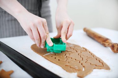 Noel ağacı zencefilli kurabiye yapıyor. Önlüklü kadın Noel kurabiyesi yapıyor.