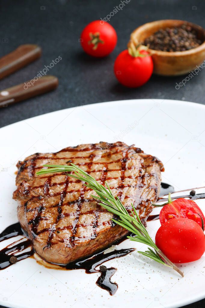 pork steak with cherry tomato and rosemary close up