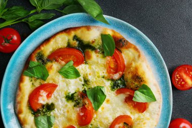 Domatesli İtalyan ekmeği, fesleğen ve deniz tuzu. Koyu beton fırın zemininde..