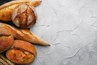 Beton zemin arkaplan görünümünde çeşitli ekmek türleri.