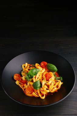 Ahşap masada marinara makarnası. Marinara soslu makarna ve ahşap arka planda taze fesleğen..