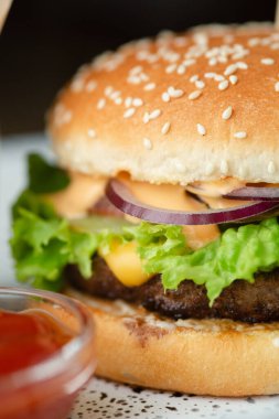 Salata peynirli, soslu, kızarmış patatesli ve fındıklı lezzetli burger..