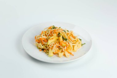 Beyaz üzerine izole edilmiş elma ve havuçlu lahana salatası. Tabakta taze vitamin salatası.